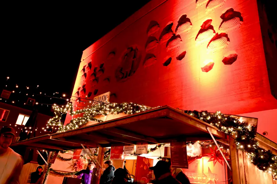 Die rot beleuchtete Fassade der Ventana über der Glühwein-Hütte